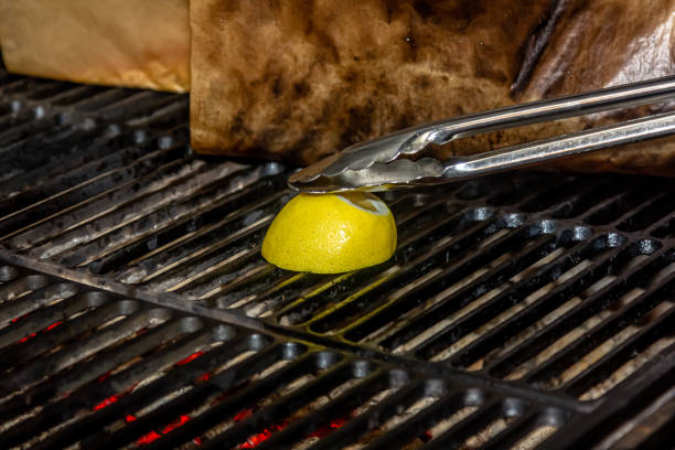 The cook roasts half a lemon on the grill