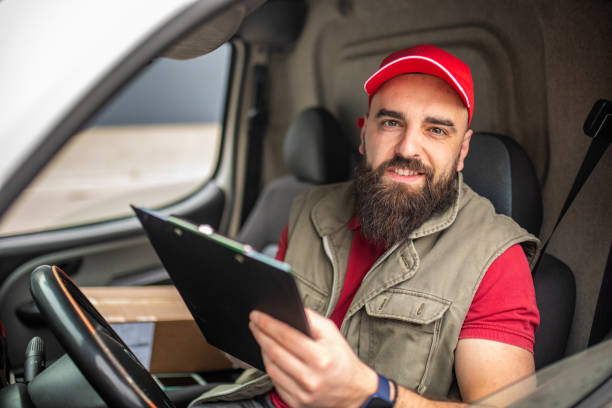 istock Portrait of delivery man in delivery van 1390866708