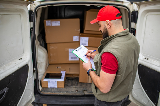 Delivery man checking a list of packages