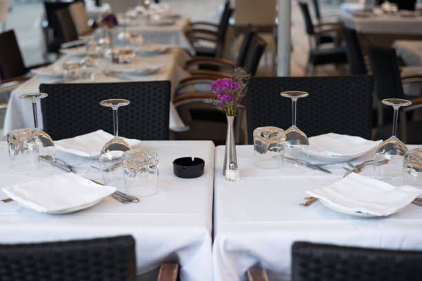 istock Restaurant table setting arrangement. Empty glasses, cutlery and napkin on a plates, table with a white tablecloth in an Italian restaurant. 1390872313