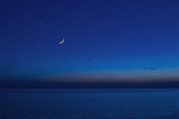 istock Moon with starry skies and planets above ocean horizon. 1390874586
