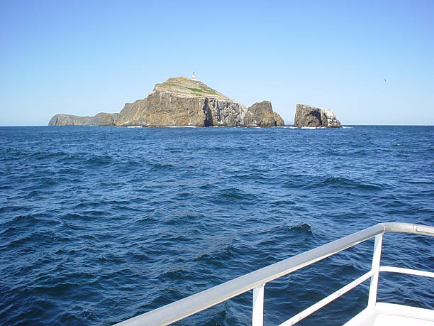 Anacapa Island and Lighthouse This shot taken from sea shows Anacapa Island and the lighthouse that sits on top warning ships to stay away from its rocky shores.  Andcapa Island lies among the Channel Islands chain in southern California. anacapa island stock pictures, royalty-free photos & images