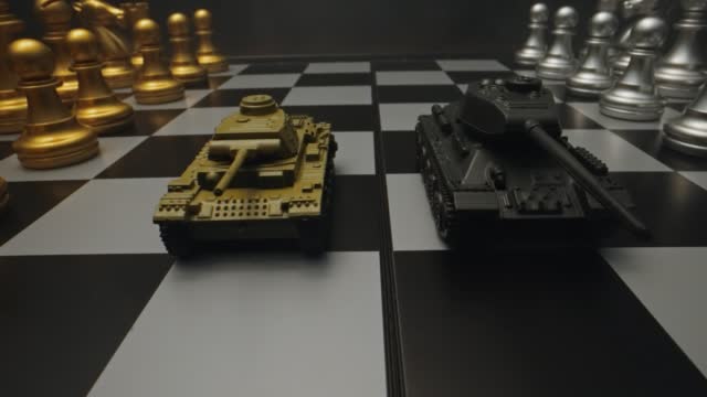 Toy tanks with chess on chessboard. Concept of military strategy.