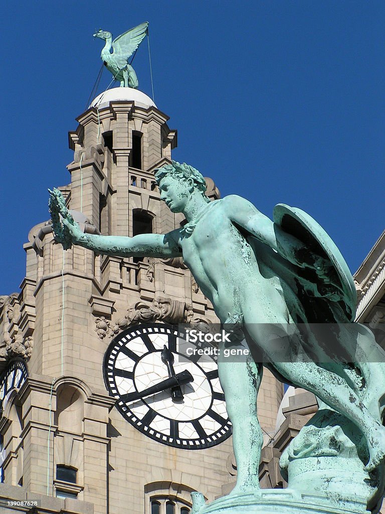 Hermes A clock tower with a bird on top behind copper statue Hermes Liverpool Bird Stock Photo