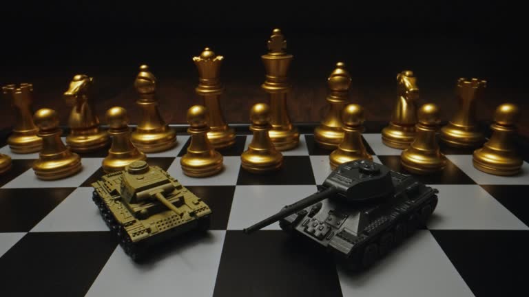 Toy tanks with chess on chessboard. Concept of military strategy.