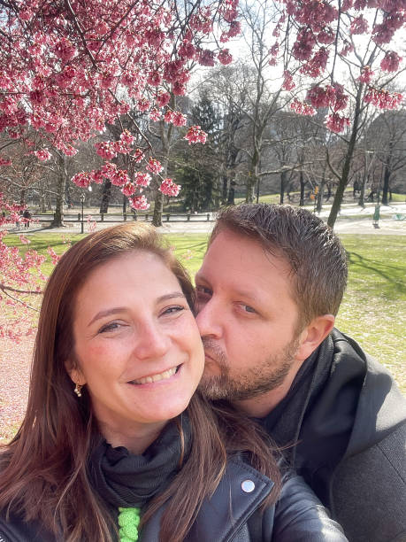istock Loving couple taking a selfie with cherry blossoms on the park 1390876740