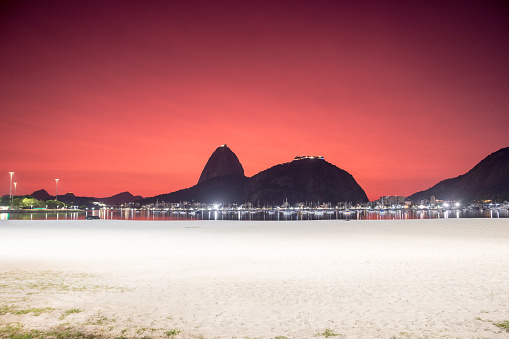 sky with the color red, under the influence of the ashes of the volcano of tonga in the cove of Botafogo in Rio de Janeiro, Brazil.