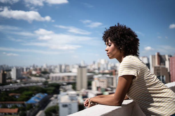 istock Contemplative young woman on apartment's balcony 1390883080