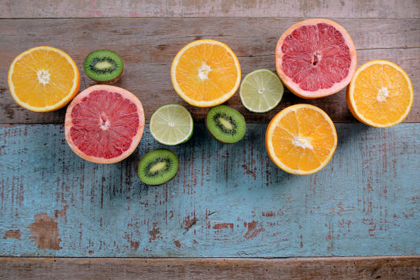 Pattern of citrus (orange, grapefruit, lemon, lime) fruit and kiwi on the wooden background