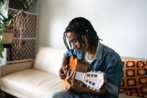 Young man playing guitar at home