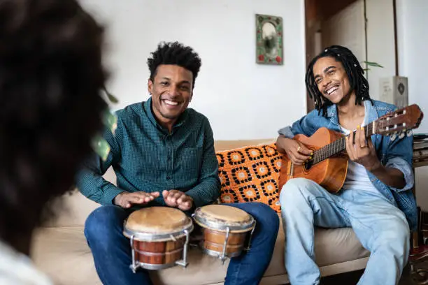 Photo of Friends playing guitar and drums at home