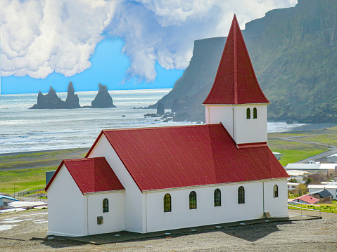 Typical red colored wooden church in Vik town, Iceland in winter. Sunrise light