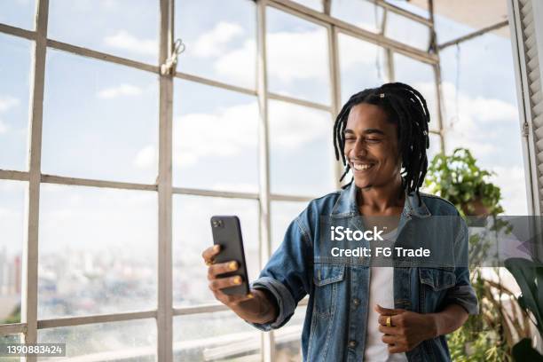 Young Man On A Video Call On The Mobile Phone At Home Stock Photo - Download Image Now