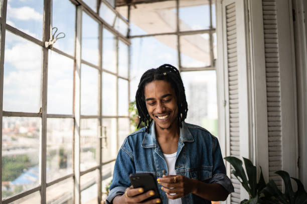 istock Young man using the mobile phone at home 1390883486
