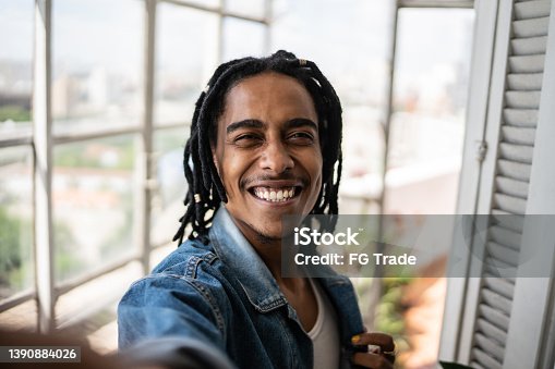 istock Young man on a taking selfie at home - camera point of view 1390884026