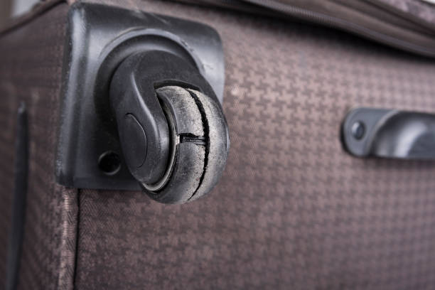 istock Worn out wheel on a rolling luggage trunk 1390884098