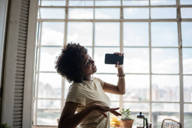 istock Young woman singing at home 1390884407