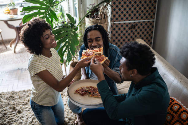 istock Friends eating pizza together at home 1390884436
