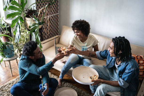 istock Friends eating pizza together at home 1390884482