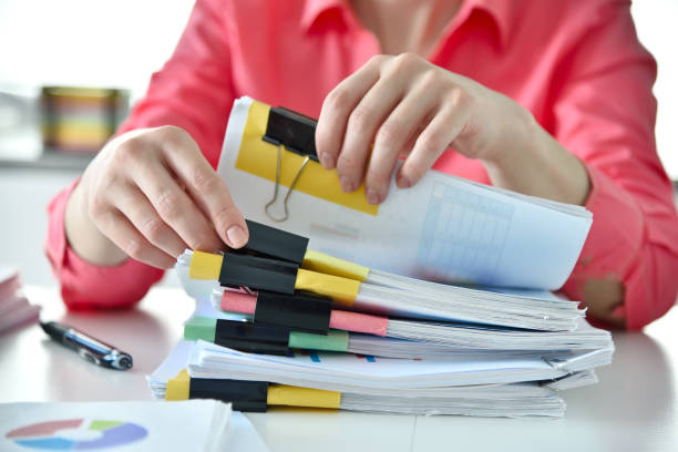 istock Accountant woman searching in stack of documents 1390884654