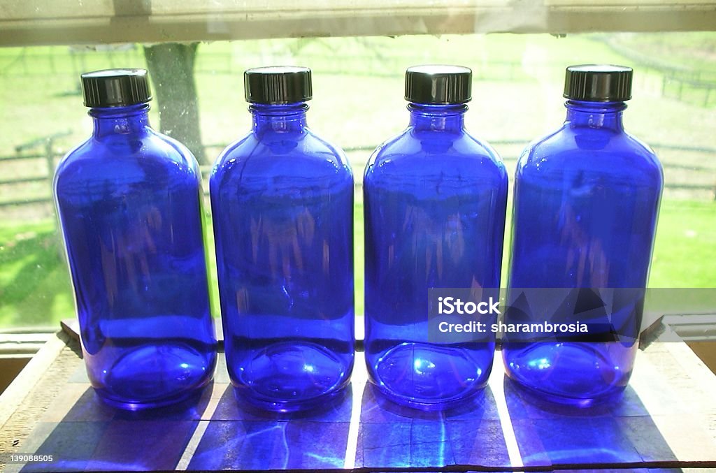Quatro garrafas azul - Foto de stock de Azul royalty-free