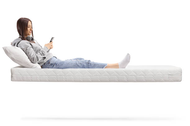 istock Feemale teenager on a floating mattress using a smartphone 1390885620