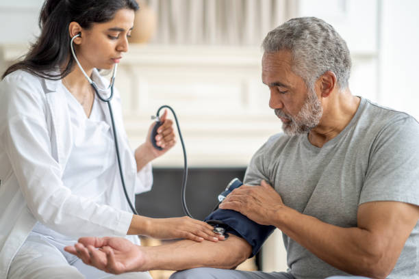 проверка артериального давления в домашних условиях - patient blood pressure gauge doctor male стоковые фото и изображения