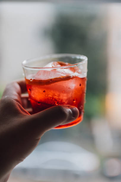 istock hand holding up red Negroni cocktail 1390887136