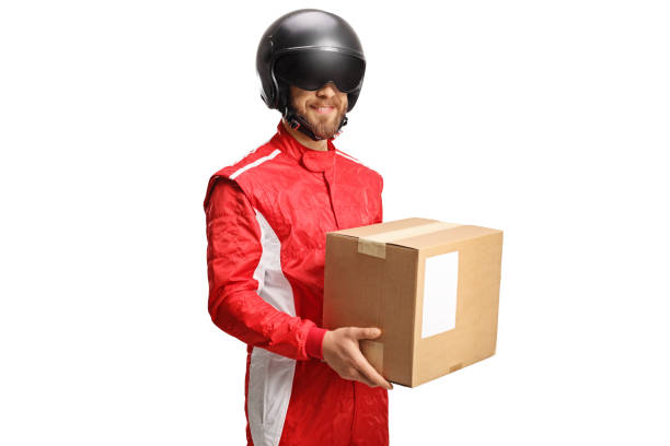 istock Man in a racing suit and helmet holding a cardboard box 1390888369