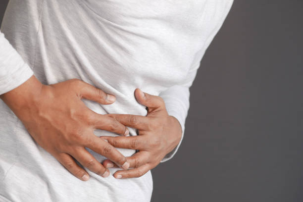istock young man suffering stomach pain close up. 1390889485