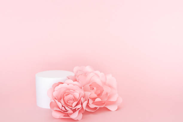 istock Circular white platform for product presentation with roses on pink background. Copy space. 1390890503