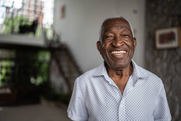 porträt eines älteren mannes zu hause - senioren männer stock-fotos und bilder