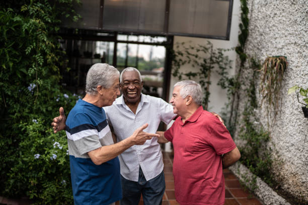 istock Happy senior friends talking at home 1390893147