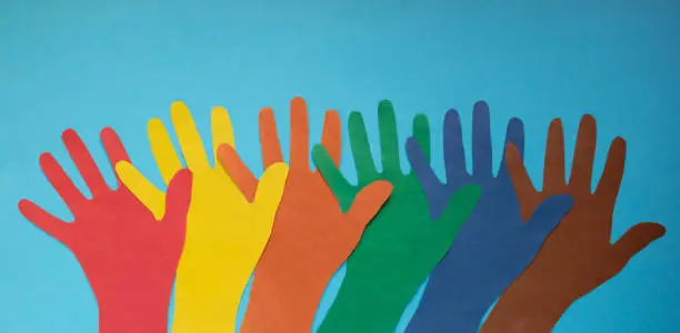 Photo of Abstract background open multicolored paper palms on a blue background.The concept of Autism Day and Youth Solidarity Day
