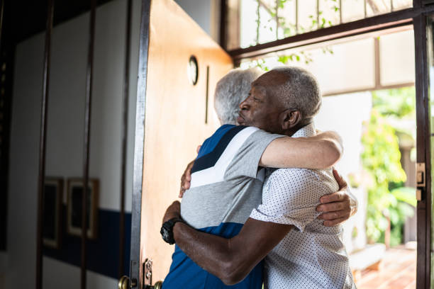 istock Senior man welcoming a friend at home 1390895768