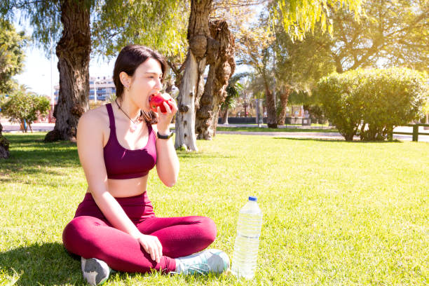 istock A girl eating an apple in a park 1390895893