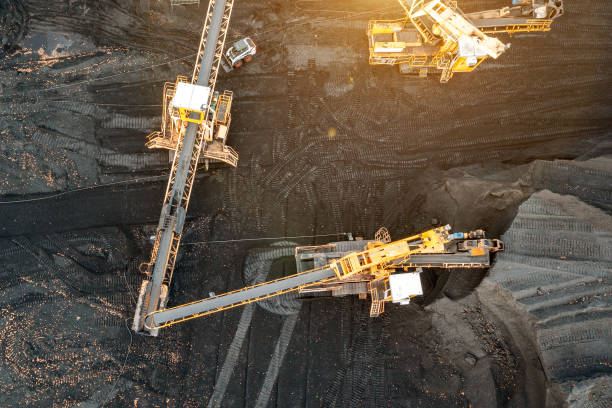 istock Large piles of coal, top view. Coal storage at the TPP, unloading and loading of coal by excavators and transport belts at the TPP warehouse. Aerial photography 1390896049