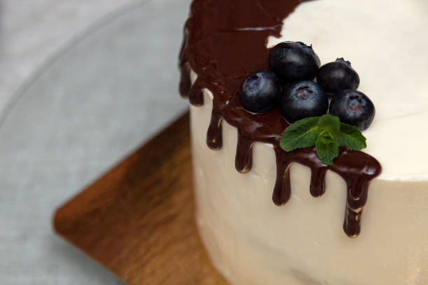 istock Fresh blueberries with mint in chocolate on the cake. Image for a website about food, confectionery. Selective focus. 1390896208