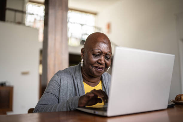 istock Senior woman using the laptop at home 1390898580