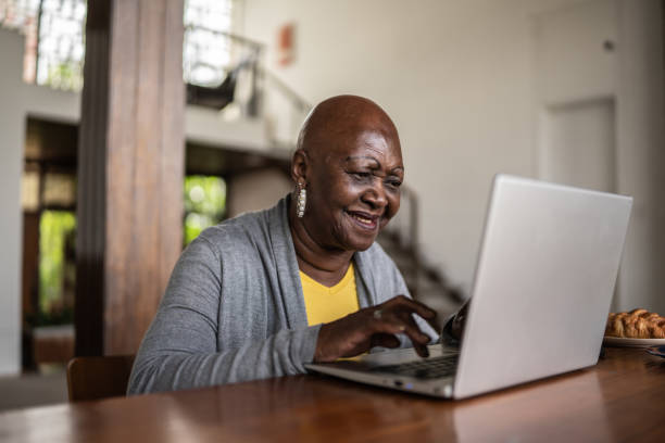 istock Senior woman using the laptop at home 1390898587