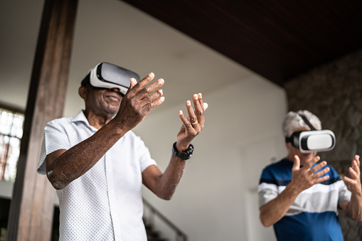 Seinor men using virtual reality glasses at home