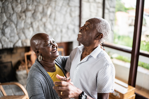 Happy senior couple dancing at home