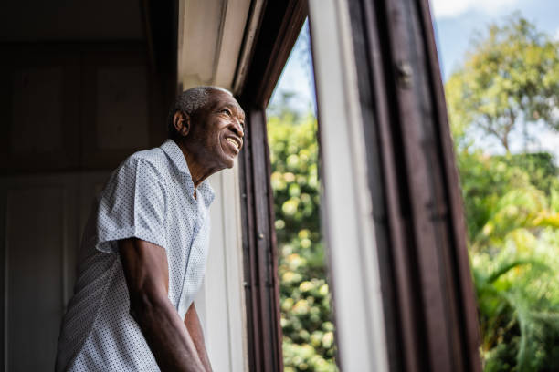 istock Happy senior man contemplating looking through the window 1390899631