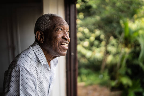 istock Happy senior man contemplating looking through the window 1390899634
