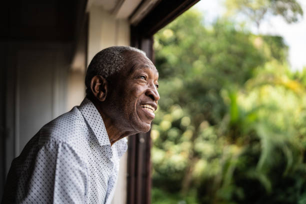 istock Happy senior man contemplating looking through the window 1390899639