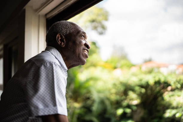 istock Happy senior man contemplating looking through the window 1390899652