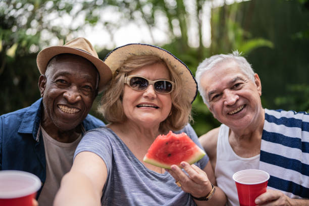 Senior friends taking selfies outdoors - camera point of view