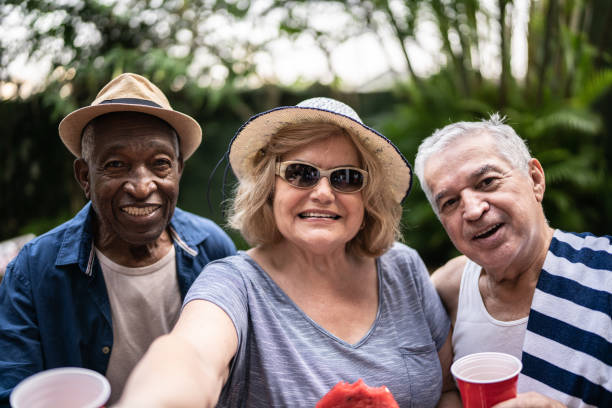 istock Senior friends taking selfies outdoors - camera point of view 1390900049