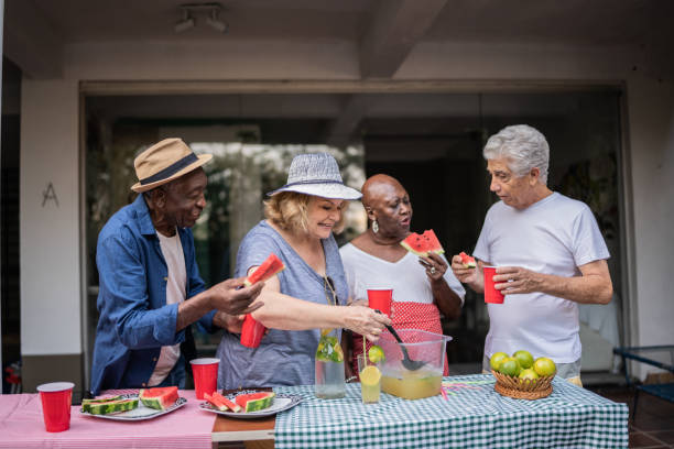 istock Senior friends eating and drinking on a pool party 1390900100