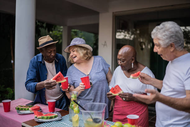 istock Senior friends eating and drinking on a pool party 1390900101
